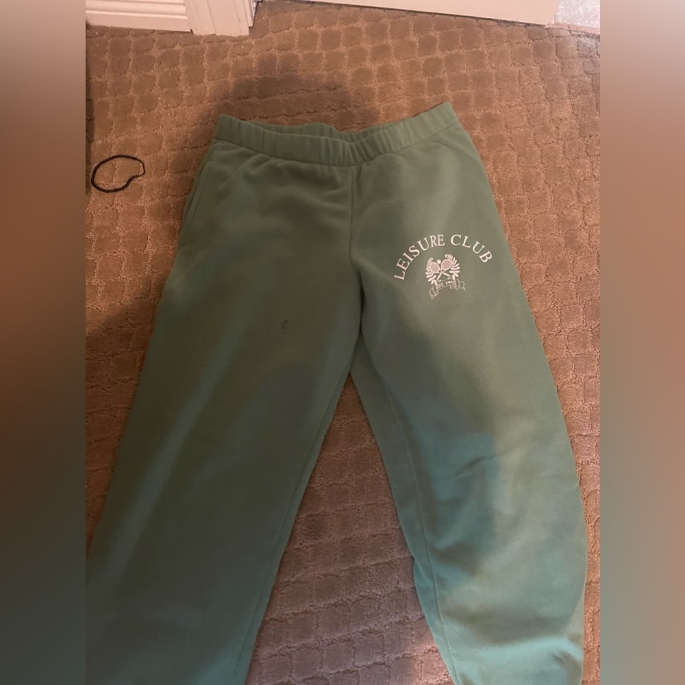 green sweatpants with leisure club symbol